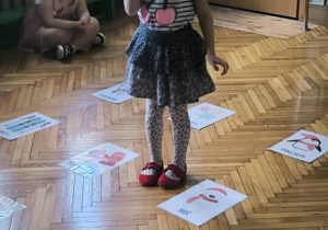 Dziewczynka stoi przy karcie do kodowania z misiem