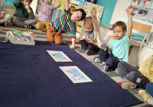 Dzieci siedzą przed ilustracjami zimowymi