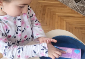 Dziewczynka przykleja elemnty do rakiety