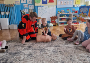Chłopiec wykonuje uciski klatki piersiowen na modelu fantoma