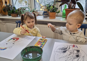 Dziewczynka i chłopiec maluja na kolorowo swoje zwierzęta