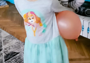 Dziewczynki tańcza z balonem za plecami