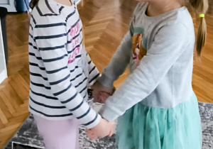 Dziewczynki trzymają balon czołem