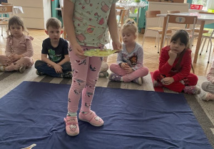 Dziewczynka zastanawia się gdzie umieścić dinozaura w formie papierowej