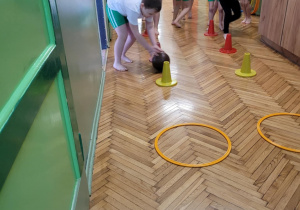 Chłopiec turla piłkę po sali gimnastycznej