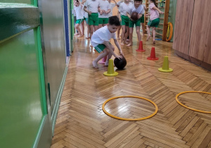 Chłopiec turla piłke pomiędzy pachołkami