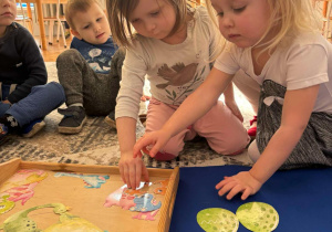 Dziewczynki wybieraja zielone dinozaury
