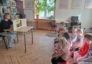 Dzieci słuchają w bibliotece Legendy o Lechu, Czechu i Rusie