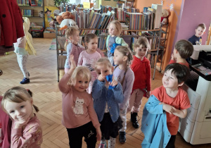 Dzieci szukające z bibliotece pozycji książkowych dla dzieci