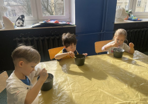 dzieci siedza przy stoliku pracując