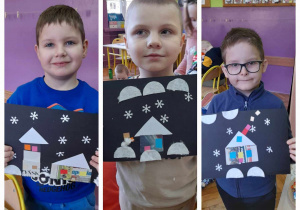 trzech chłopców prezentuje swoje prace plastyczne, na których umieszczone są domki, płatki śniegu, oraz wata imitująca śnieg