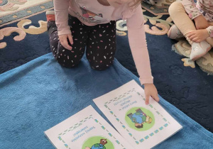 dziewczynka wybrała i kladzie ilustrację, która mówi jak należy dbać onasza planetę
