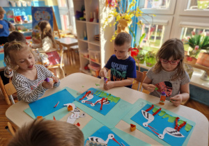 Dzieci przyklejają trawę wydartą z zielonego kartonu