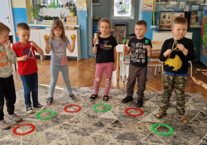 Dzieci stoją w półkolu i grają na instrumentach
