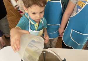 Chłopiec wlewa sok z cytryny do misy robota