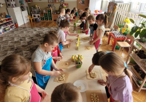 Dzieci kładą kulki na papierze do pieczenia i firmułuja baranka wielkanocnego