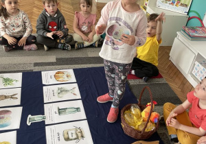Dziewczynka pokazuje ilustrację pisanek