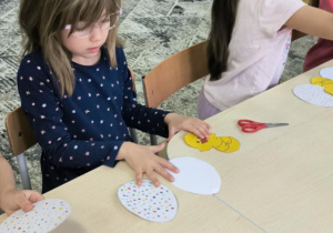 Dziewczynka przykleja kurczaczka w jajku