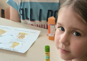 Dzieci siedzą przy stoliku z karta pracy
