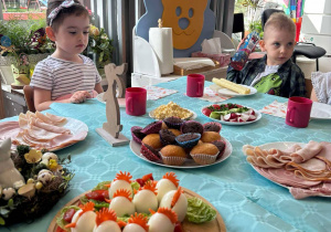 Dziewczynka i chlopiec siedza przy stole wielkanocnym