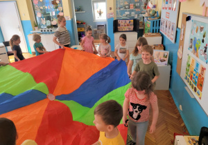 dzieci poruszają się trzymając w rękach chuste animacyjną