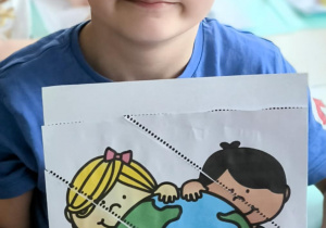 Chłopiec pokazuje sklejone puzzle