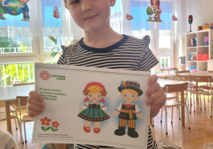 Dziewczynka pokazuje regionalny strój łowicki