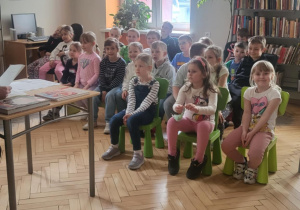 dzieci biorą udział w zajęciu czytelniczym