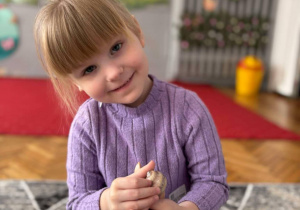 dziewczynka uśmiecha się trzymając skorupkę slimaka