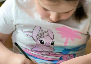 Dziewczynka koloruje na czarno drobne kropki