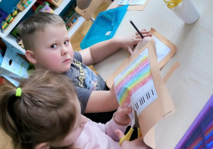 Dziewczynka wycina przy stole nożyczkami