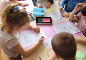 Dzieci kolorują obrazek odczytując cyfry