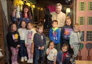 dzieci pozuja do zdjęcia z katorami stojąc ba scenie