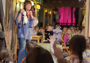 dzieci oglądają aktora, który prazentuje lalki wykorzystywane podczas przdstawienia