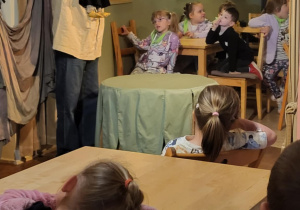 dzieci oglądają aktora, który prazentuje lalki wykorzystywane podczas przdstawienia