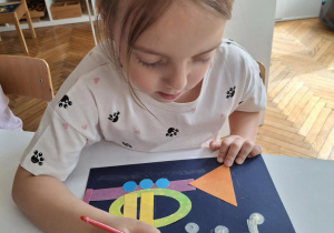 Dziewczynka maluje nutki nad trąbką