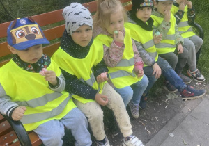 Dzieci siedza na ławce w parku