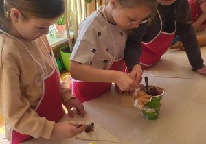 Dziewczynki nakładają marmoladę na ciasto
