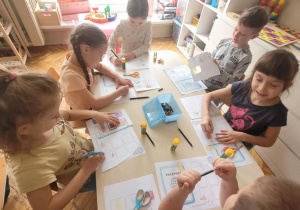 Dzieci przy stoliku wykonują paszporty z podróży po Europie