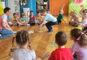 dzieci siedzą na podłodze grając w grę matematyczną gąsiennicę