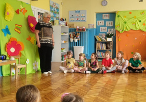 Pani Dyrektor wita dzieci, które siedzą na podłodze