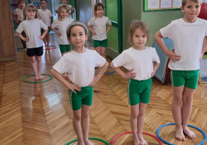 Dzieci stoją w kolorowych kołach