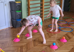 Chłopiec rozkłada piłki na pachołki