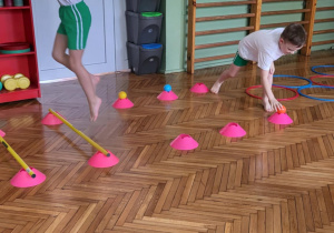 Dziewczynka przeskakuje przeszkodę