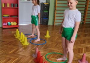 Dziewczynka i ch.,opiec stoją w obręczach