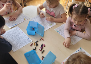 Dzieci przy stoliku wykonują kodowanie