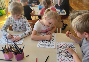 Dzieci przy stole wykonują portret mamy