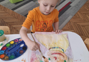 Chłopiec kolorouje portret mamy