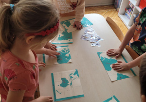 Dzieci ukladaja mapę świata