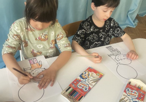 Dzieci kolorują obrazek chłopca z balonem